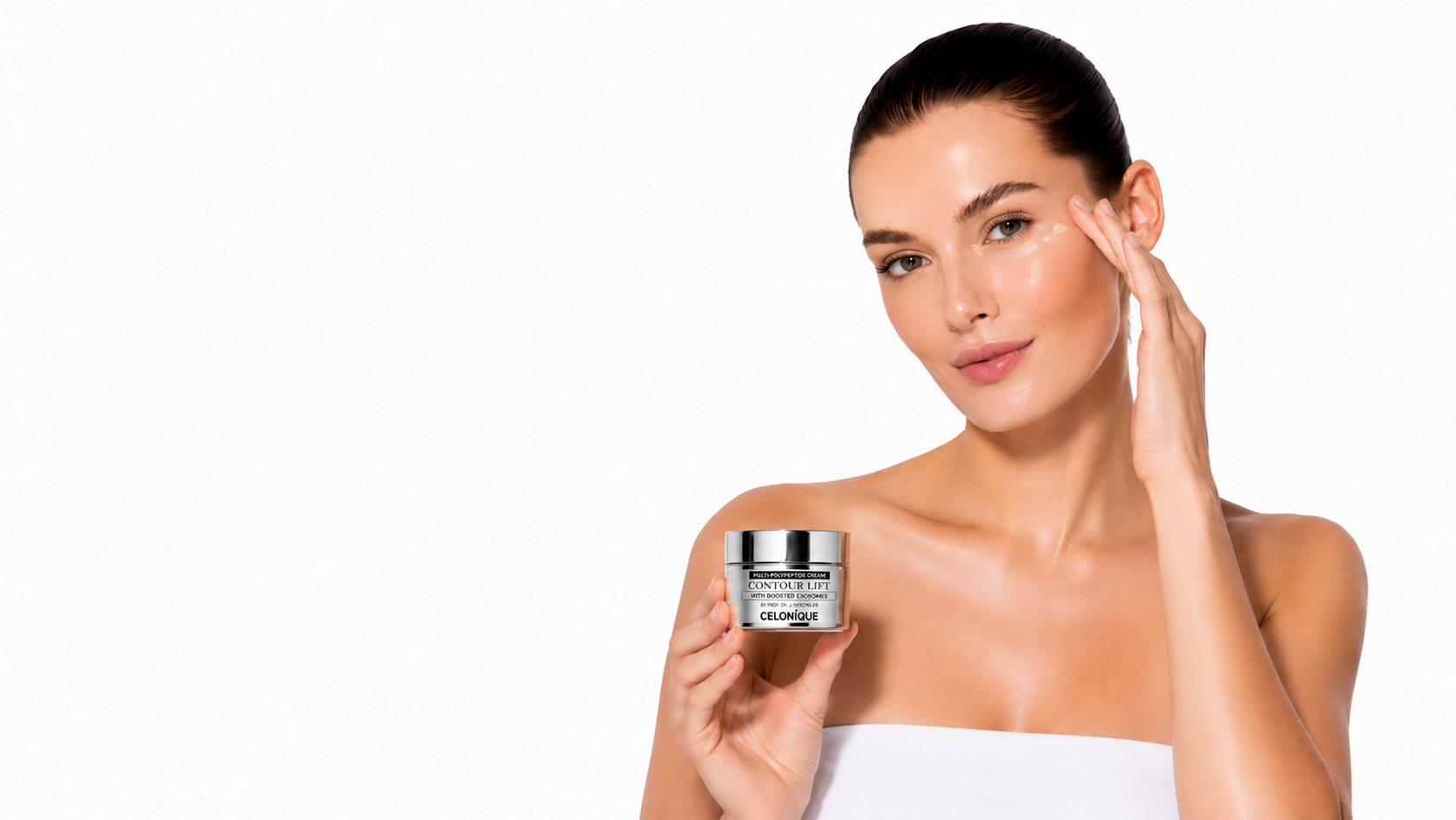 Woman holding CELONIQUE regenerative skincare cream while gently touching her face on a clean white background.