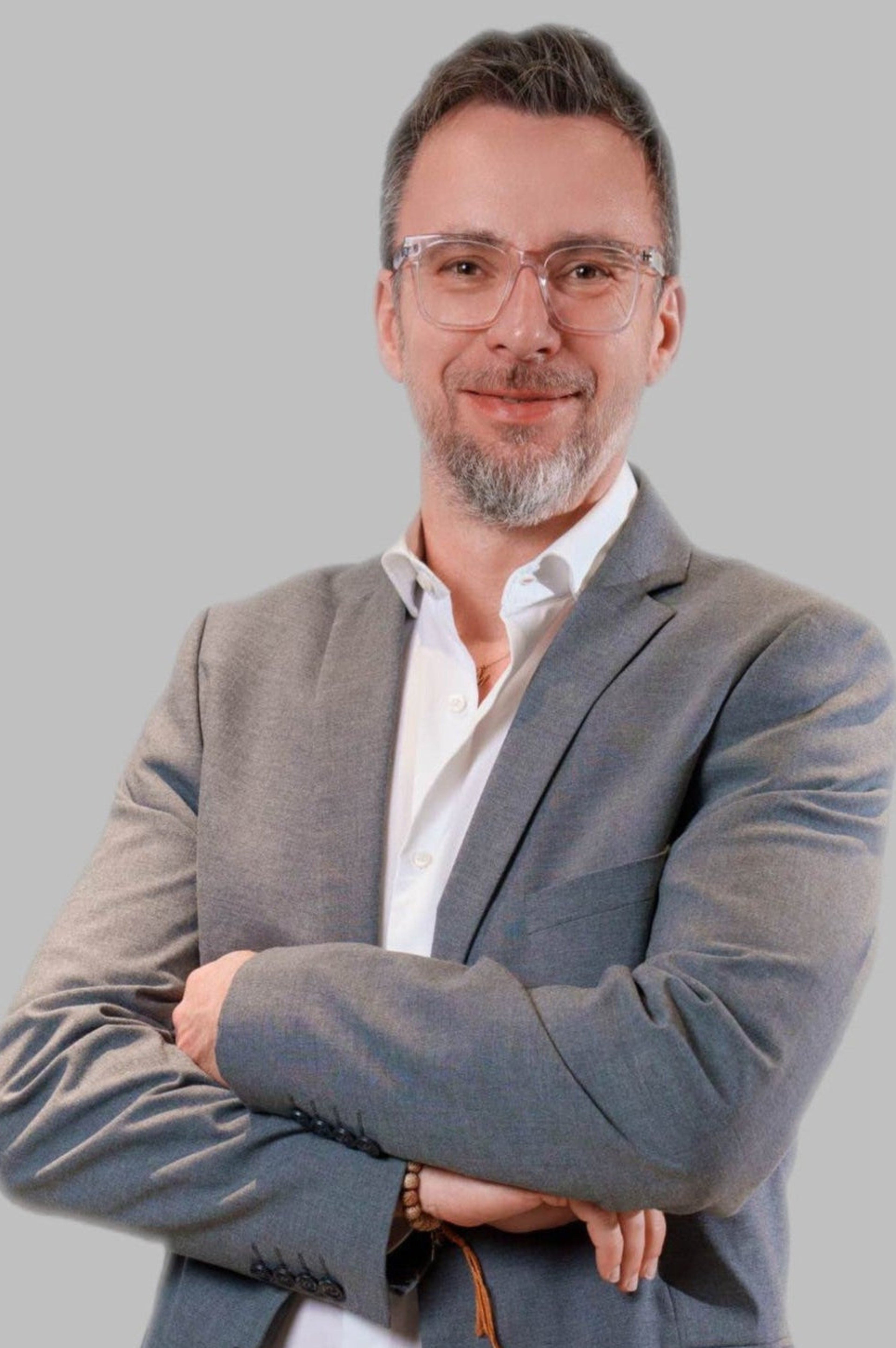 Daniel Matthieu, Geschäftsführer von CELONÍQUE, im grauen Anzug vor neutralem Hintergrund. Professionelles Businessporträt für Unternehmenskommunikation.