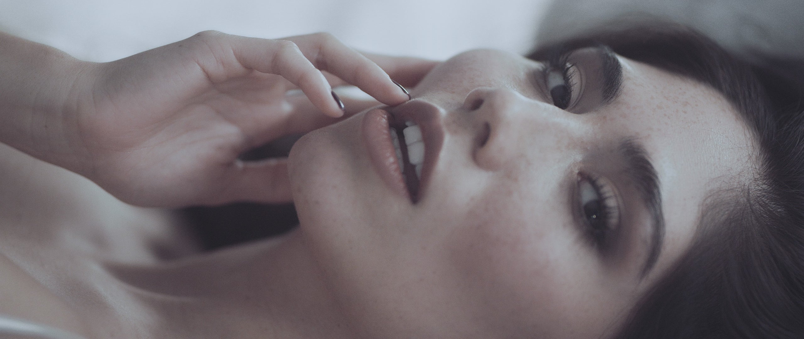 Ästhetisches Nahaufnahmevideo einer Frau in ruhiger Atmosphäre, mit Fokus auf weiche Gesichtszüge und Emotion – symbolisiert Zartheit und Intimität.